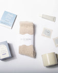 Set of items including a mug, socks, and tea packages on a white background