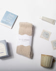 Set of beige luxe socks with tea boxes, a mug, and a tube on a white background