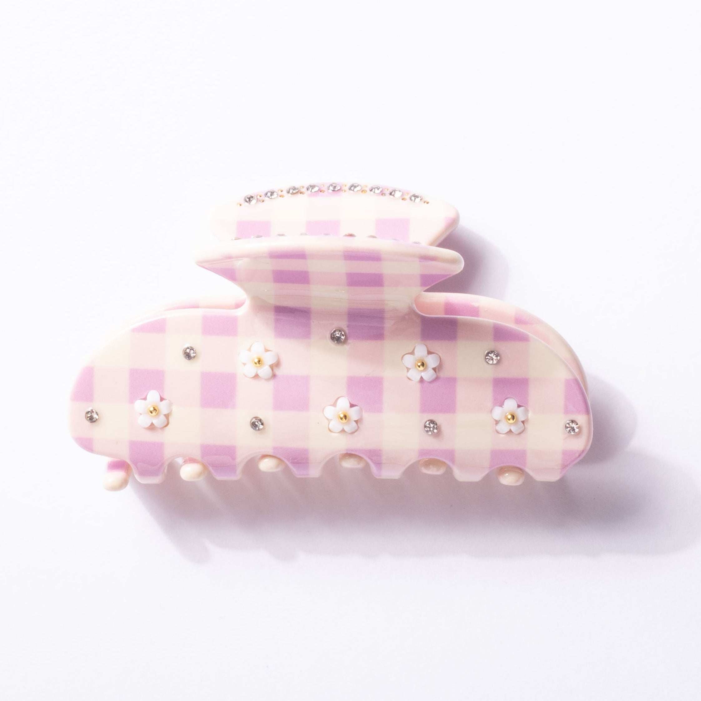 Pink and white checkered hair clip with decorative elements on a light pink background