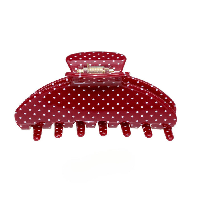 A glossy red hair claw clip with white polka dots, shown against a plain white background.