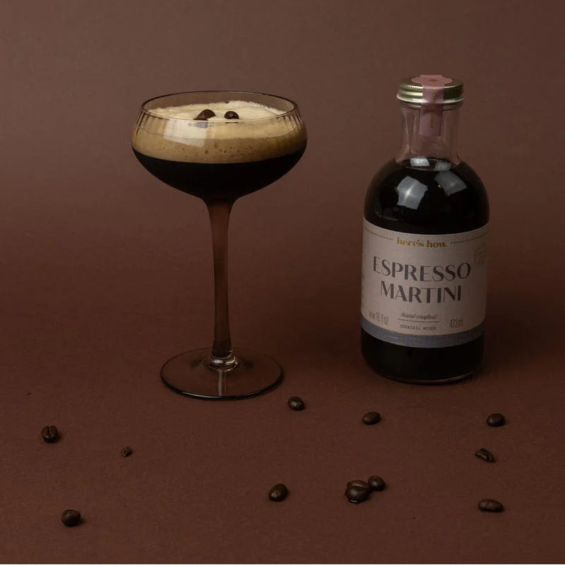 Espresso martini in a glass with bottle on a brown background