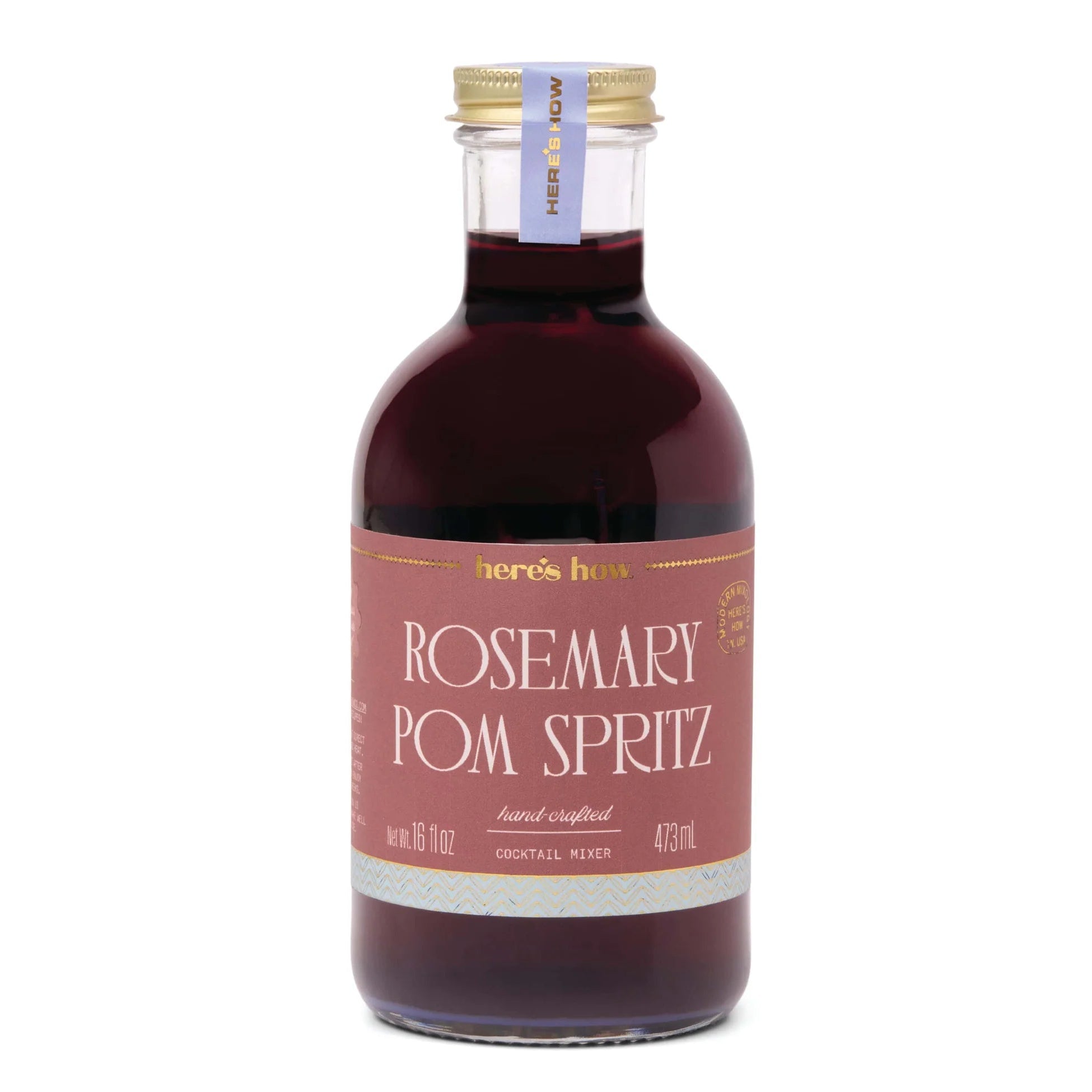 Clear bottle with red liquid and a gold cap with a label that says "rosemary pom spritz" in white writing