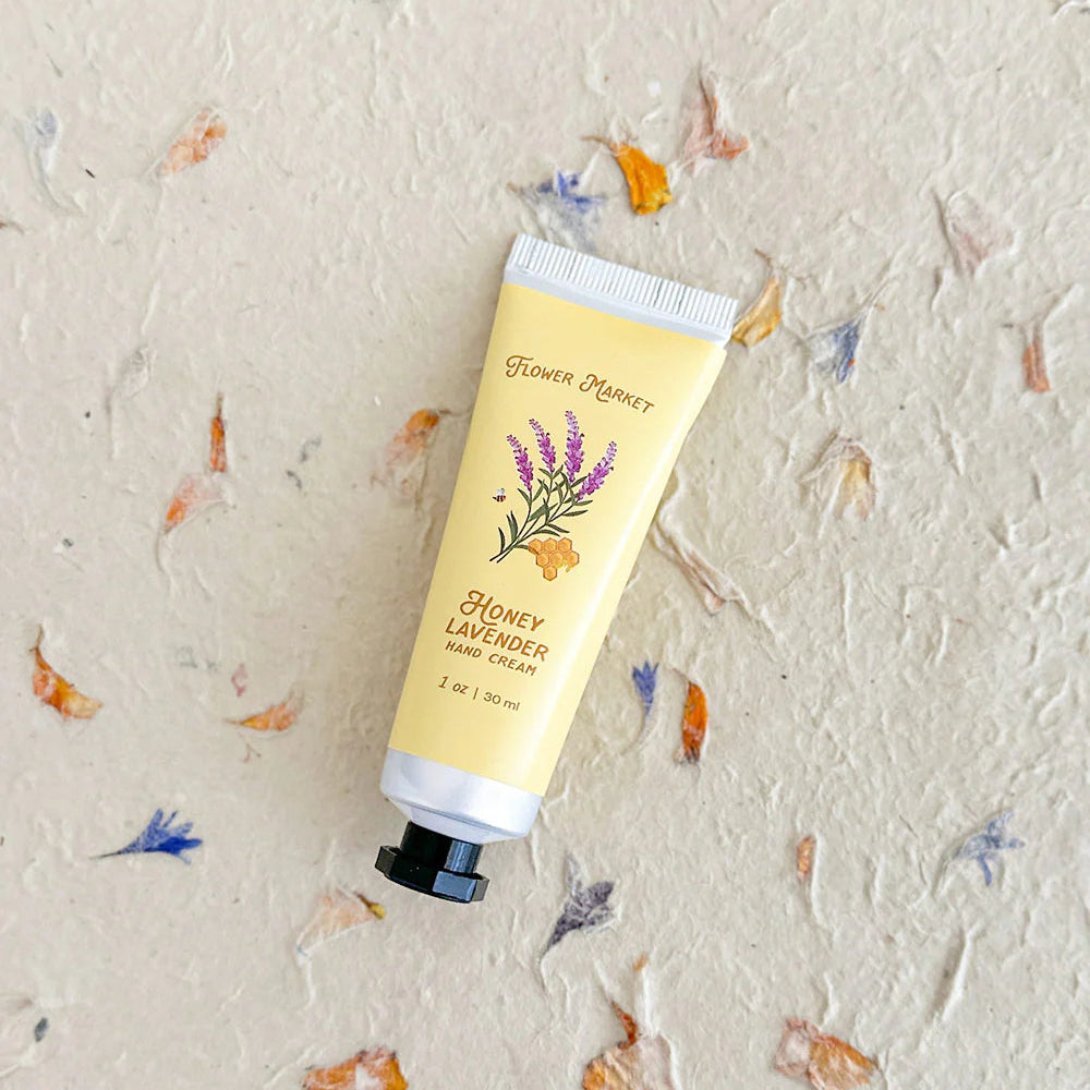 Hand cream tube labeled 'Honey Lavender' on a textured background with floral decorations