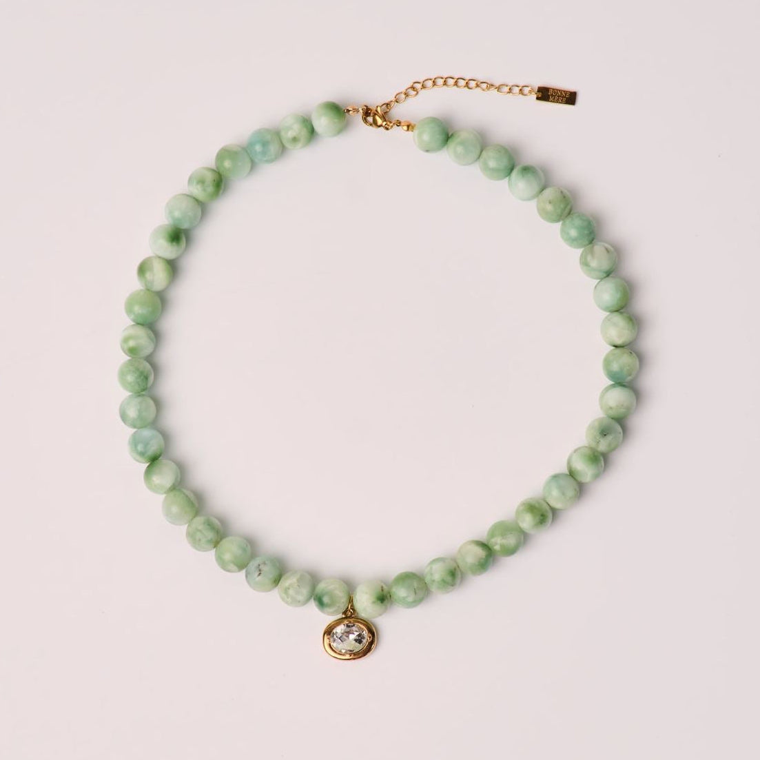 green necklace with diamond hanging down 