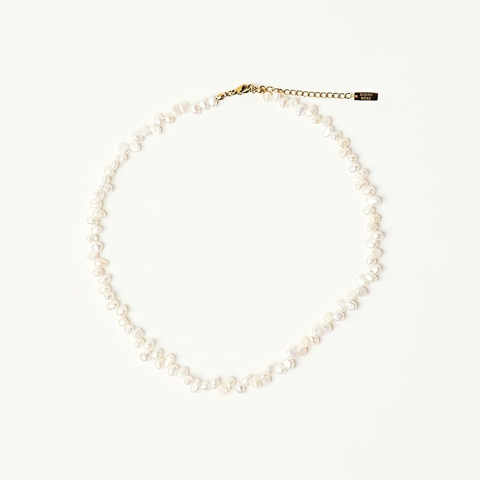 A delicate necklace made of small white beads with a gold-tone clasp, displayed on a clean white background.