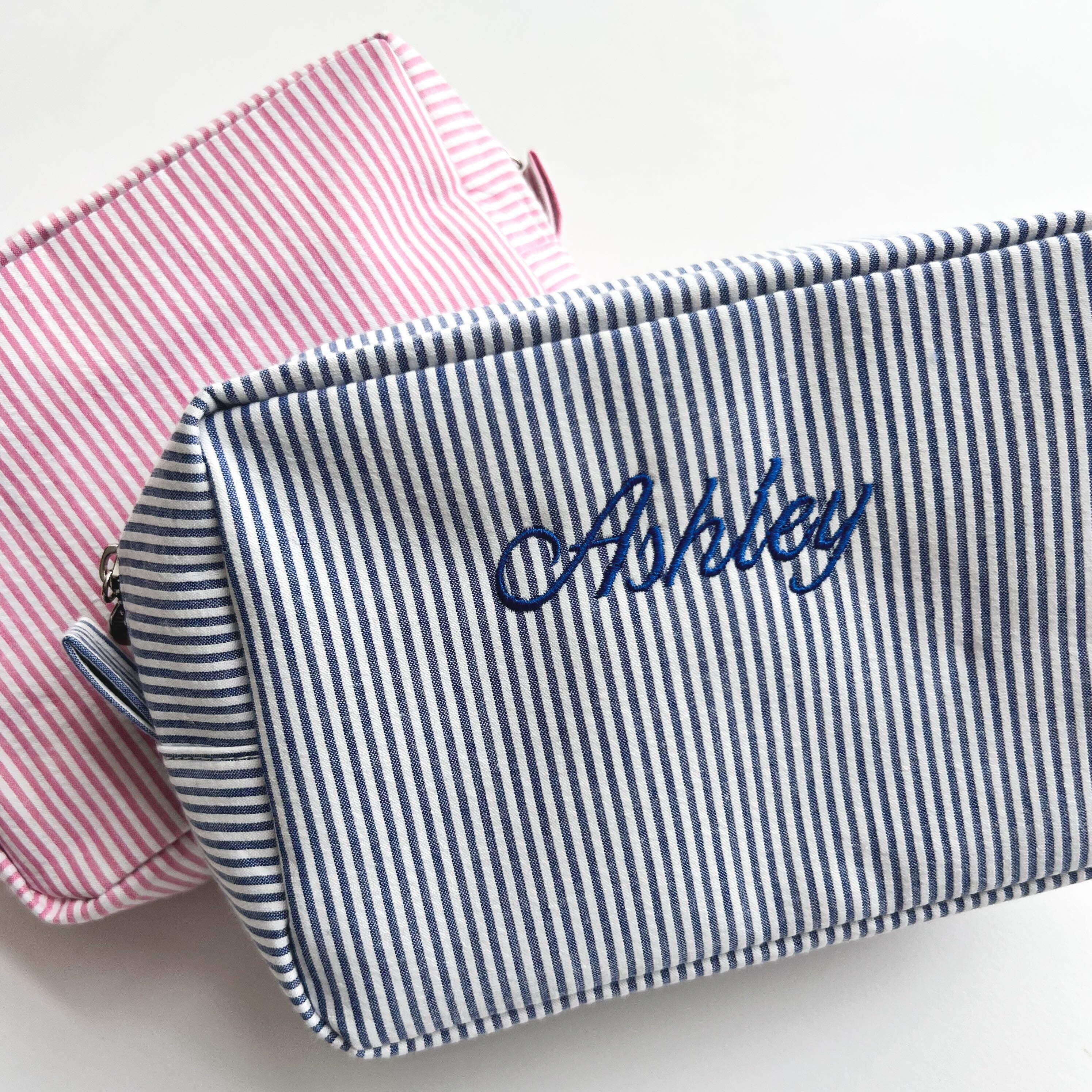 Pink Striped Makeup Bag with navy striped bag on top of it