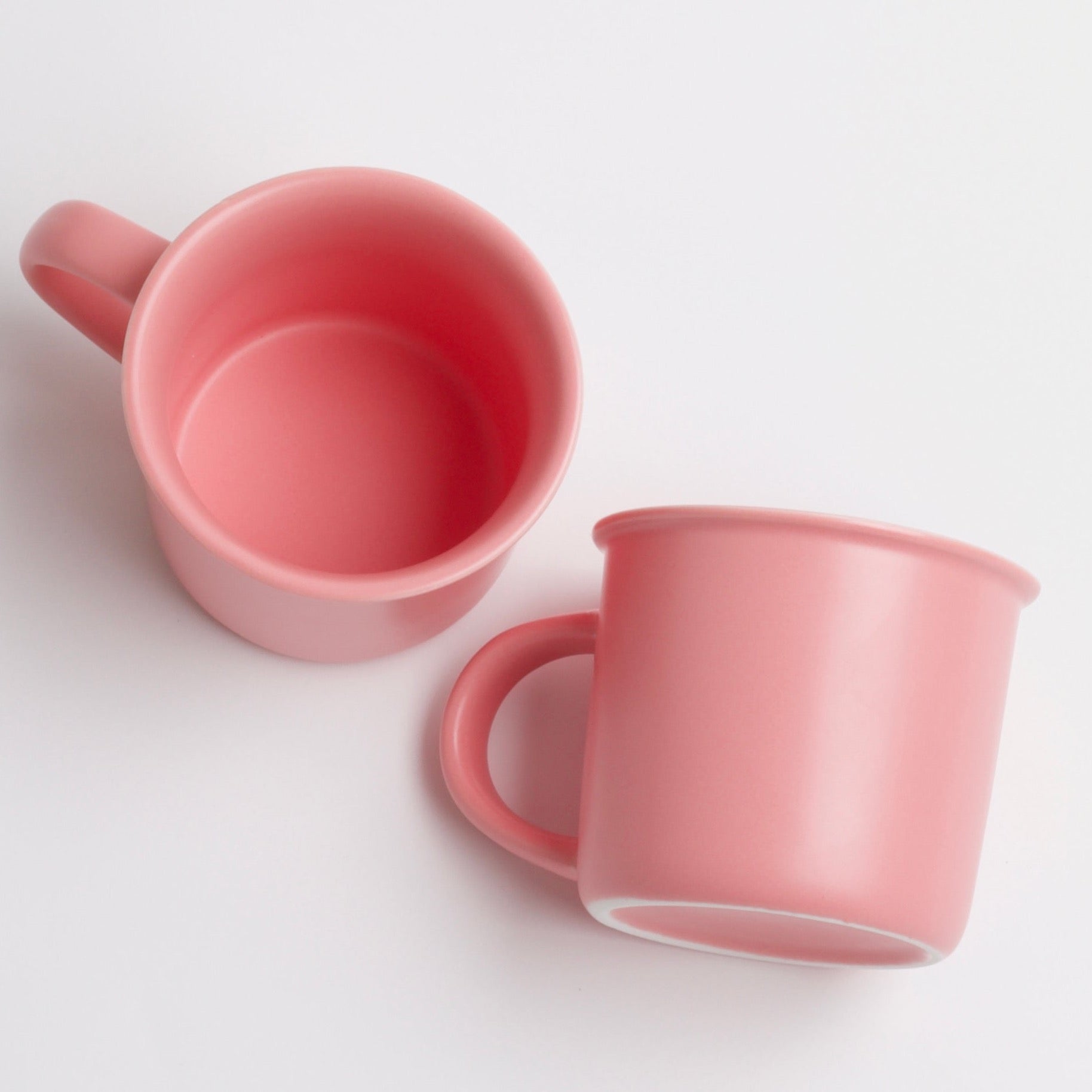 Two empty pink ceramic mugs