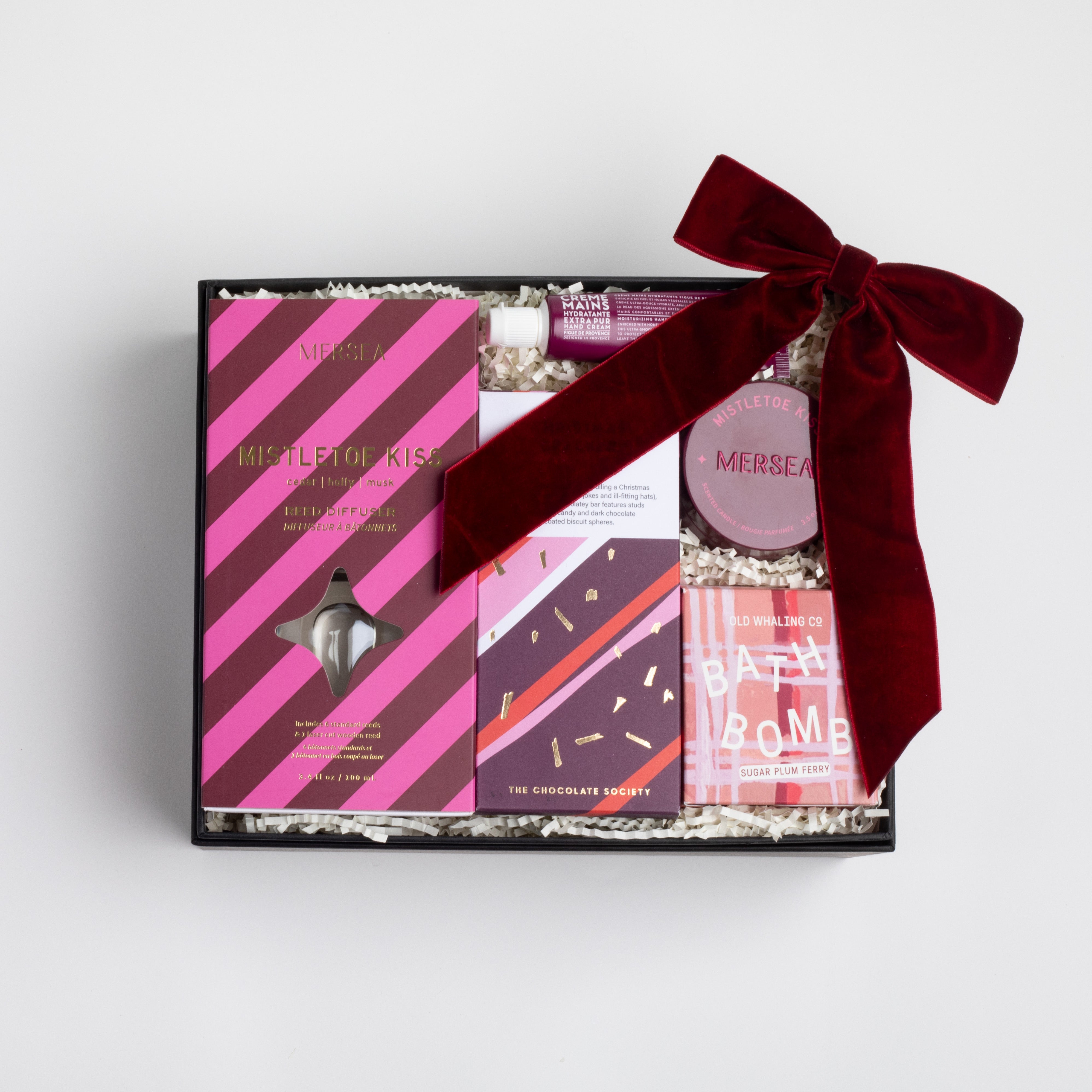 BLACK BOXFOX BOX OPEN WITH: Mistletoe Kiss Reed Diffuser, Mistletoe Kiss Tin Candle, Christmas Cracker Bar, Sugarplum Ferry Bath Bomb, Maroon Velvet Bow Hair Clip, Fig of Provence Travel Hand Cream