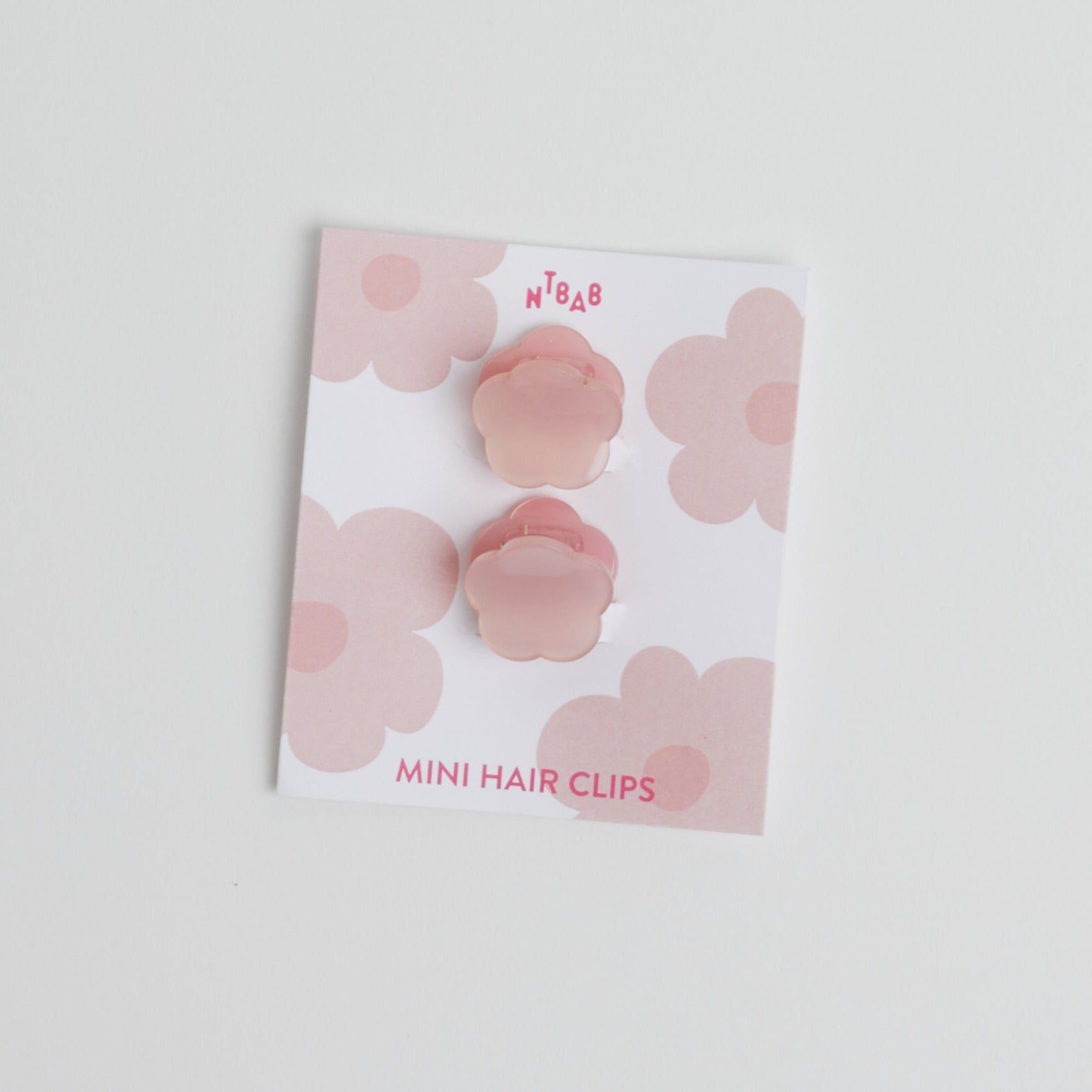Two Pink Mini Flower Hair Clips in packaging on white background