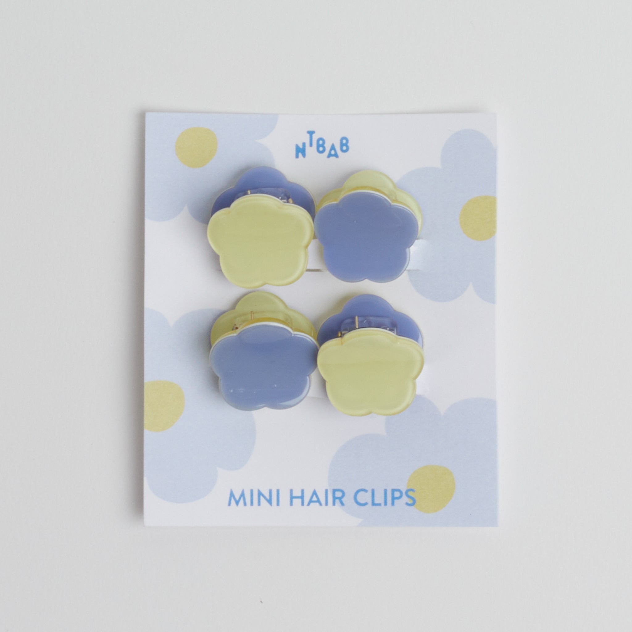Blue + Green Mini Flower Hair Clips | Set of 4 in packaging on white background.