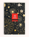 Black rectangular notebook with gold embossed celestial design all over. Red matchbook in middle of book has white text that reads, "Burn After Writing". Photographed on white background.