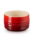 Red ceramic ramekin on a white background