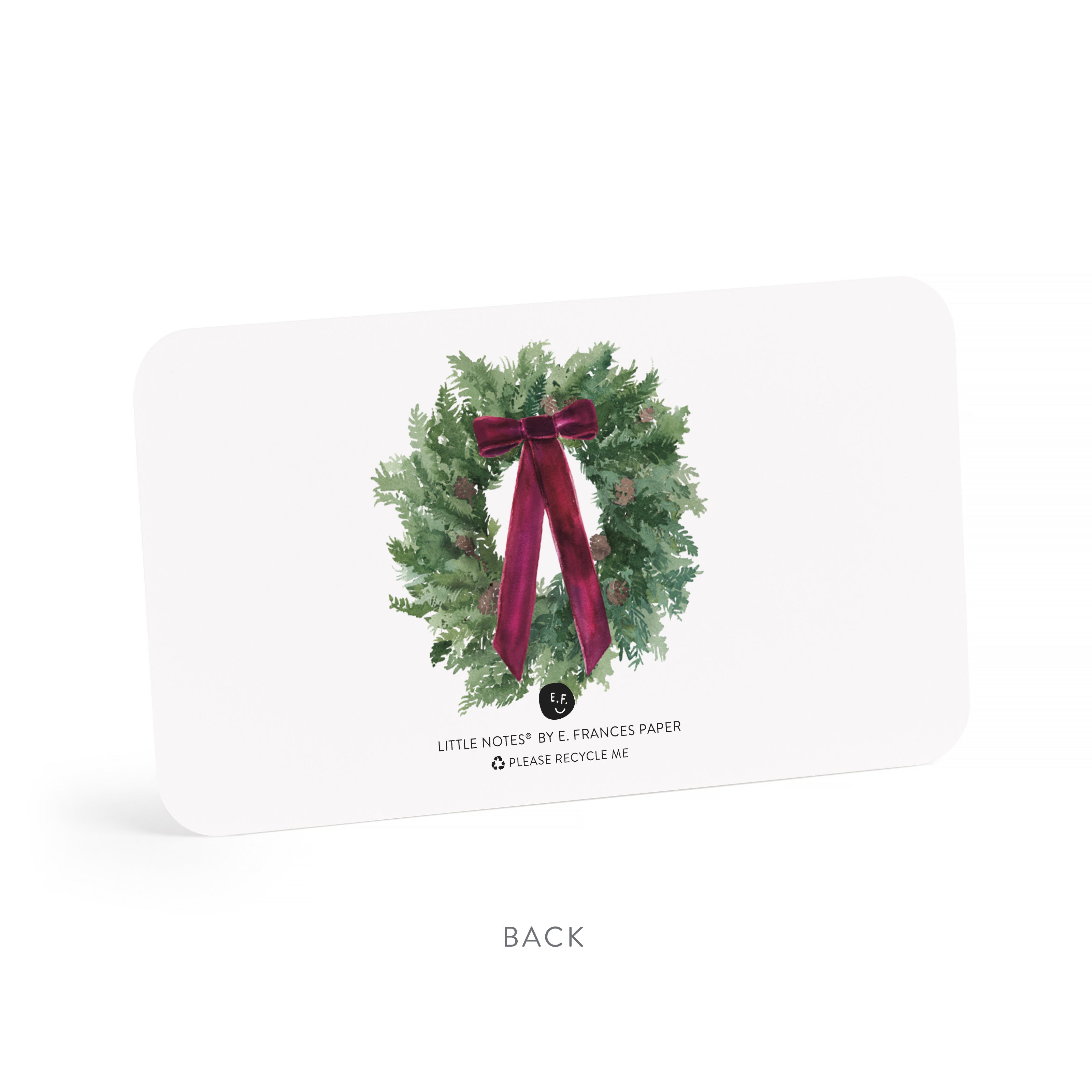 Note card with a Christmas wreath design featuring a red bow on a white background.