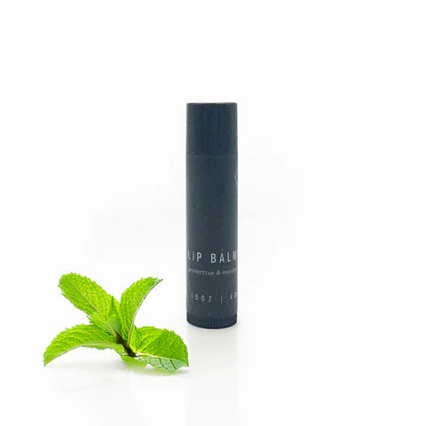 Lip balm container with a mint leaf on a white background