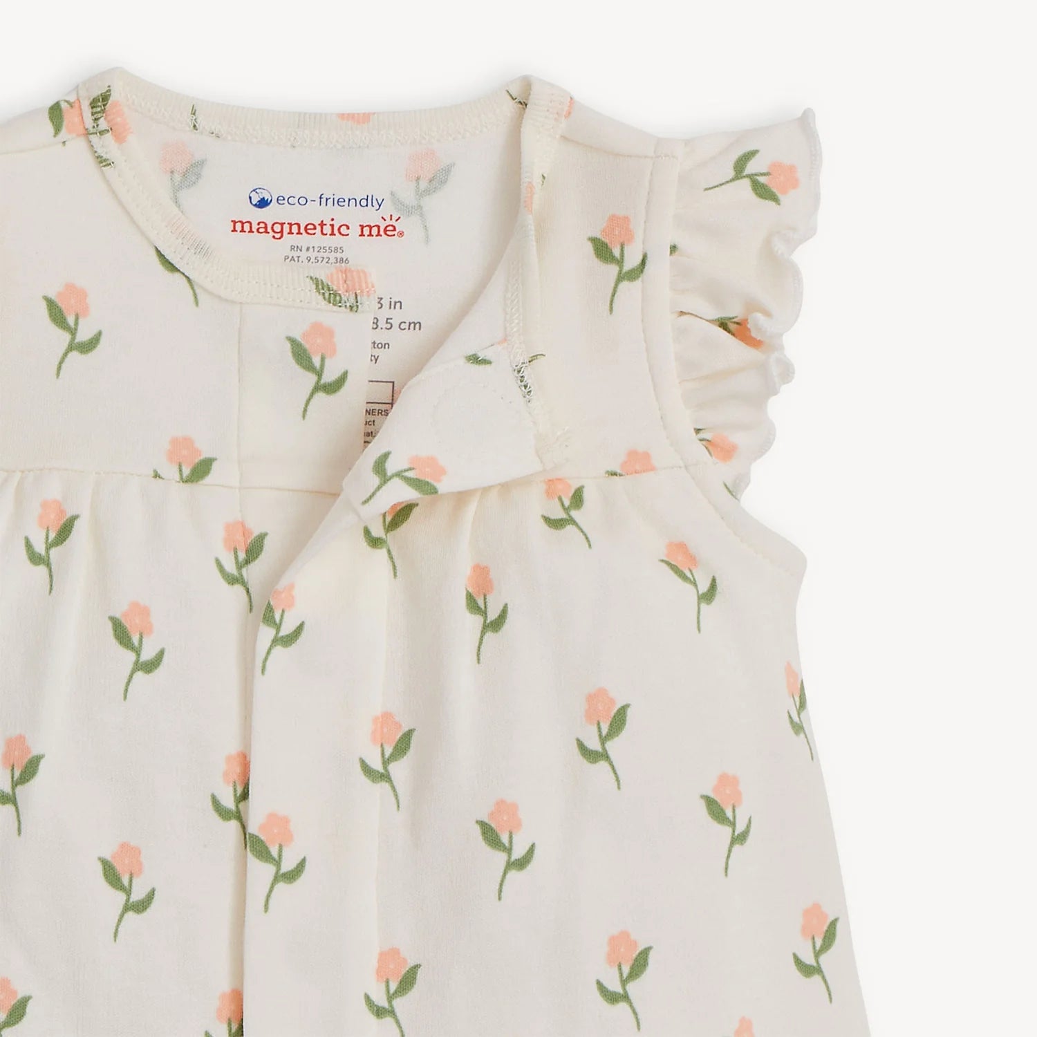 Baby romper with floral pattern and 'magnetic me' label on a white background