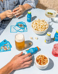 Friends play card game with cocktails, snacks and Morning Recovery.