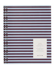 A spiral-bound notebook with horizontal dark purple and white stripes, featuring a white label on the front with the brand name 'STAN' and product details, set against a plain white background.