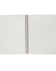 An open spiral-bound notebook with lined pages, photographed against a plain white background.