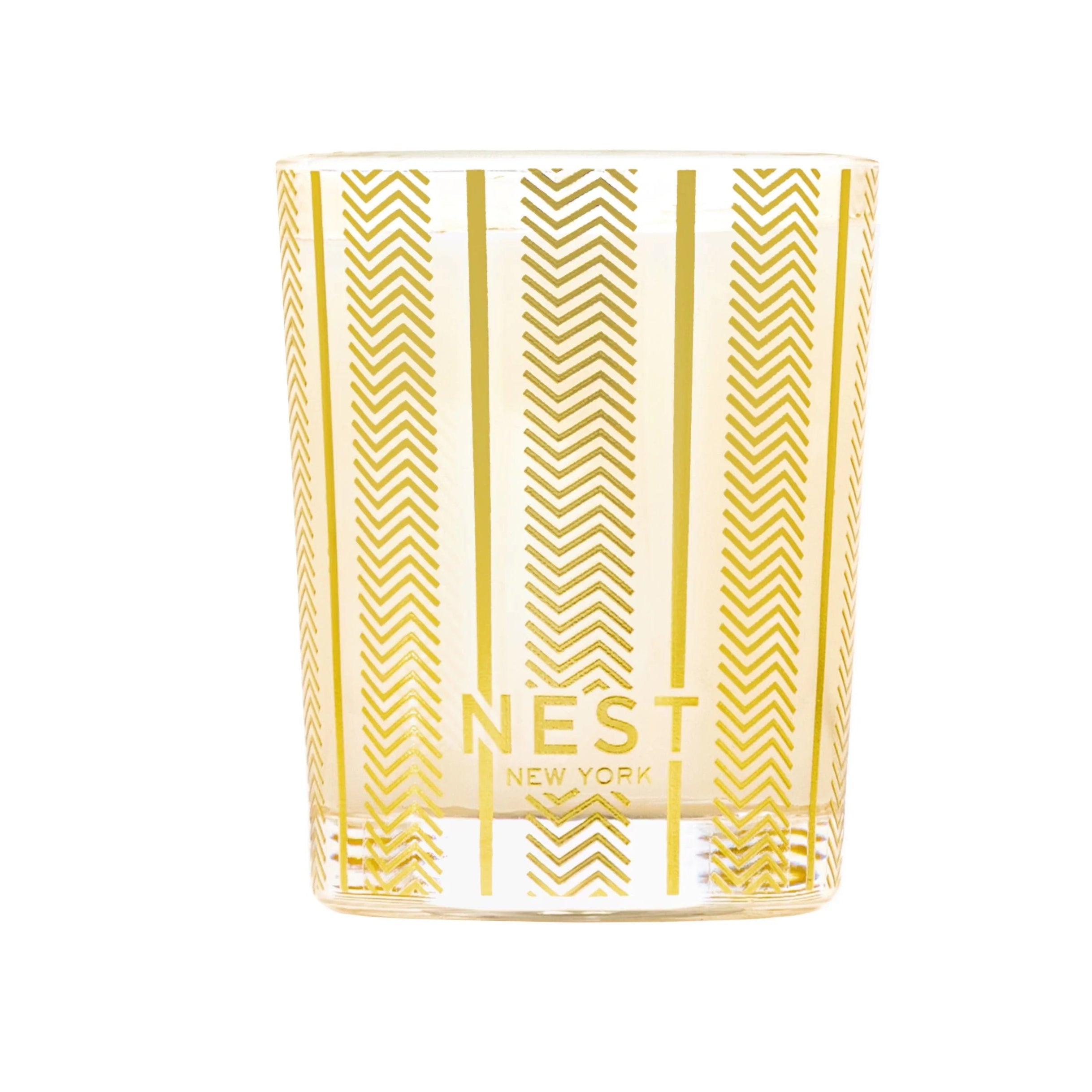 Candle in a glass jar with gold chevron pattern and 'NEST New York' branding on a white background