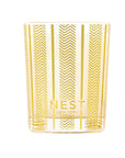 Candle in a glass jar with gold chevron pattern and 'NEST New York' branding on a white background