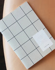 Milo Weekly Planner | Light Gray Grid on leather couch