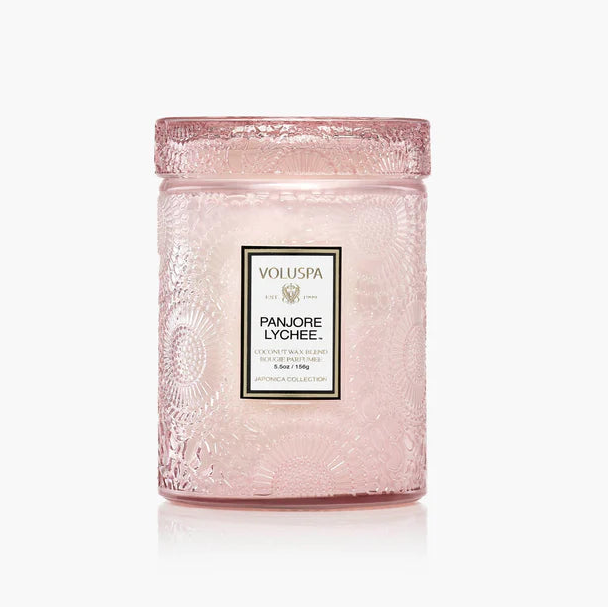 Pink candle with Voluspa branding on a white background