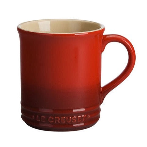 Red mug with darker color gradient at the bottom. Bottom has Le Ccreuset embossed into the mug. Inside of the mug is creme