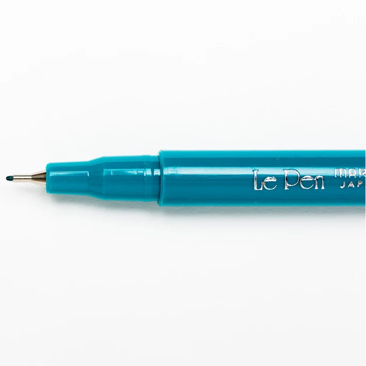 A close-up of a teal blue Le Pen fine liner pen with its fine tip visible, positioned horizontally on a clean white background.