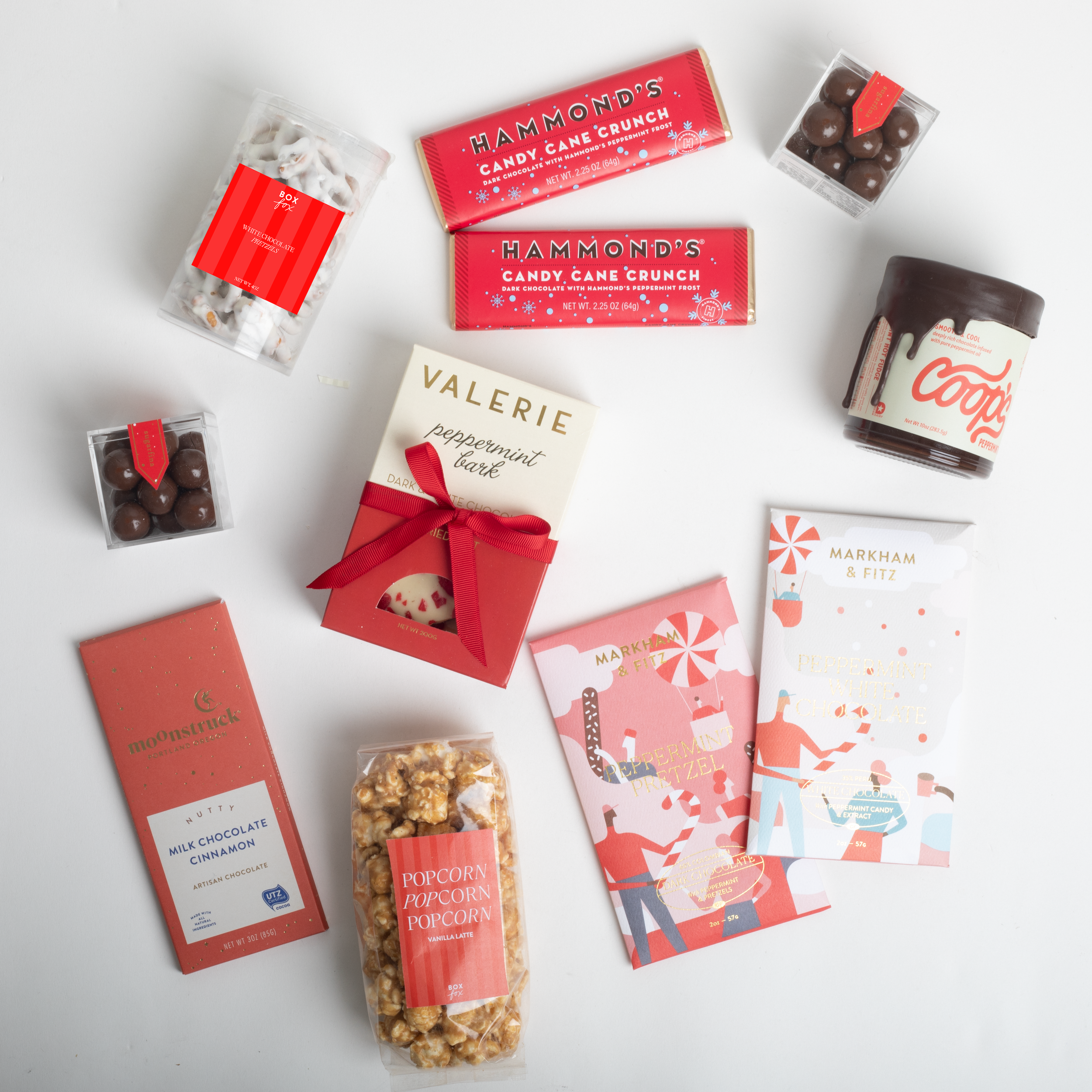 Assorted confectionery items including chocolate bars, popcorn, and candy on a white background