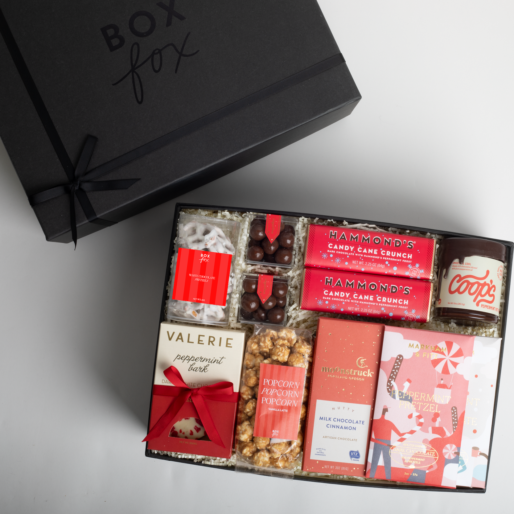 Gift box with various confectioneries and a black 'Box Fox' branded box on a light gray background