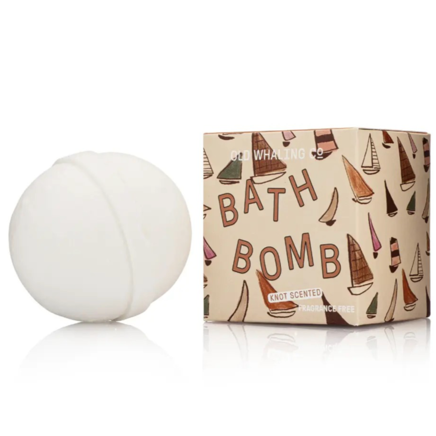 Bath bomb next to box with sailboats on white background