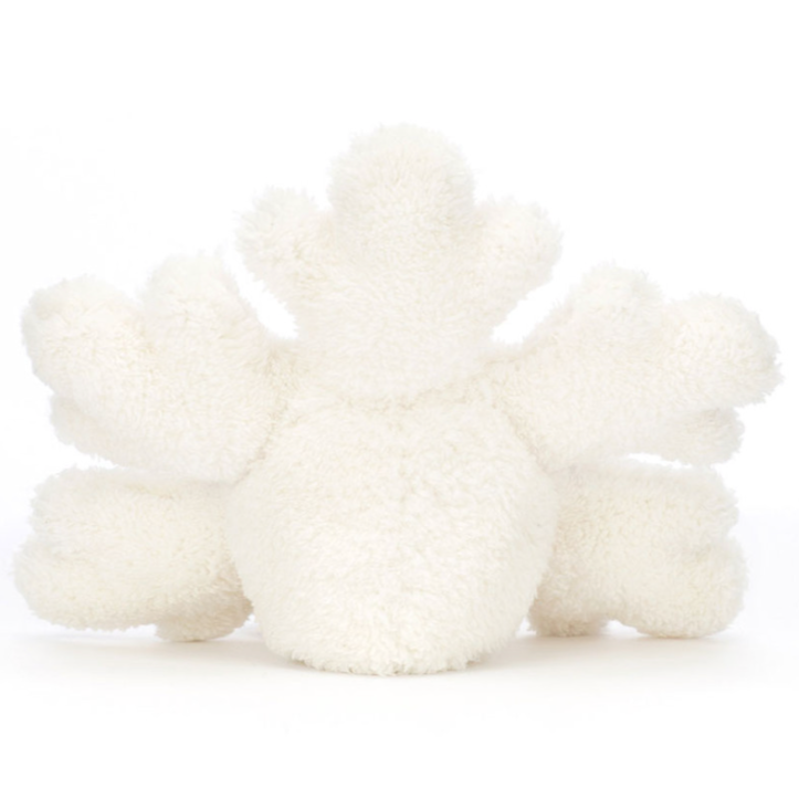 A snowflake stuffed animal sitting down back facing on a white background