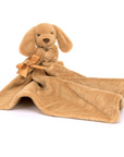 Brown puppy with an attached blanket on a white background