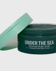 dark green body scrub with mint green cap behind white background