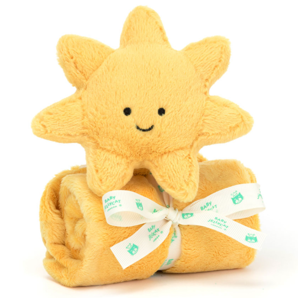 yellow sunshine stuffed animal on top of rolled yellow blanket behind white background 