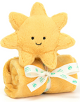 yellow sunshine stuffed animal on top of rolled yellow blanket behind white background 