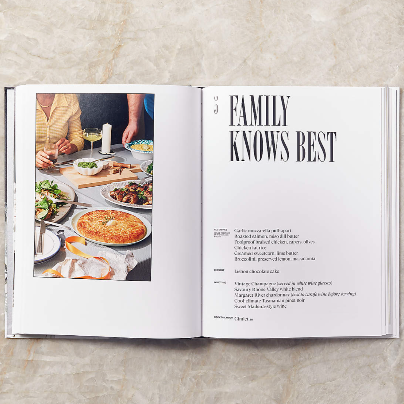 The Dinner Party Book is displayed open with the headline "FAMILY KNOWS BEST." There is a picture of pizza, salad on a table.