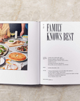 The Dinner Party Book is displayed open with the headline "FAMILY KNOWS BEST." There is a picture of pizza, salad on a table.