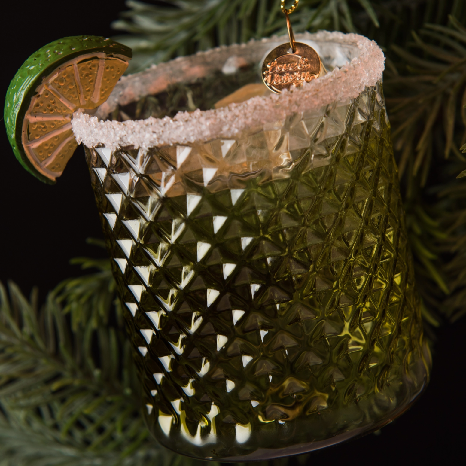 Handblown glass ornament shaped like a margarita hanging from Christmas tree 