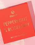 red box of bath salt soak that reads musee peppermint & rosemary in gold writing on pink background with salt visible 