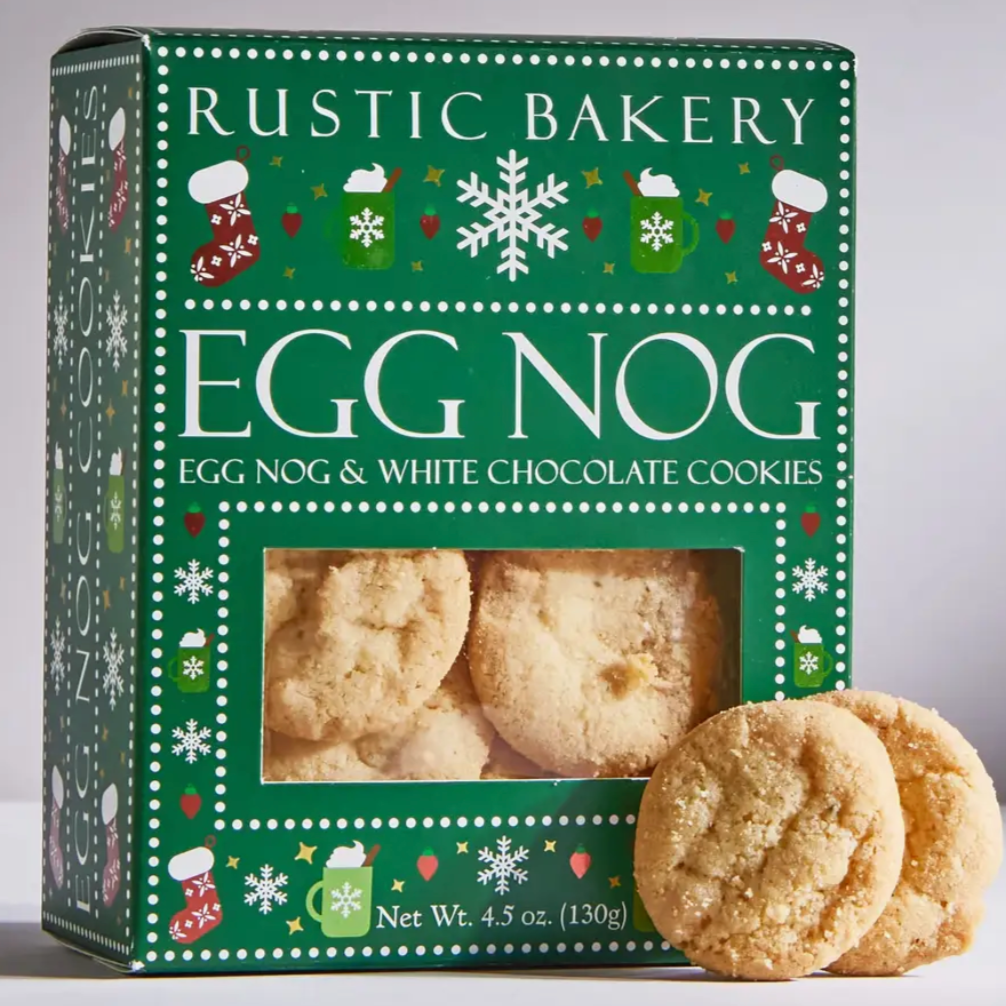 Green red and white rustic bakery box of egg nog & white chocolate cookies with two cookies outside of the box.