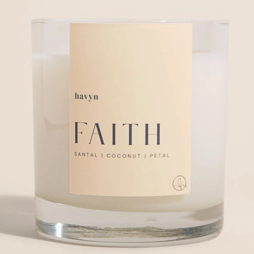 candle with beige on it by havyn that says faith santal coconut petal candle is clear with white wax o 