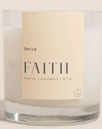 candle with beige on it by havyn that says faith santal coconut petal candle is clear with white wax o 