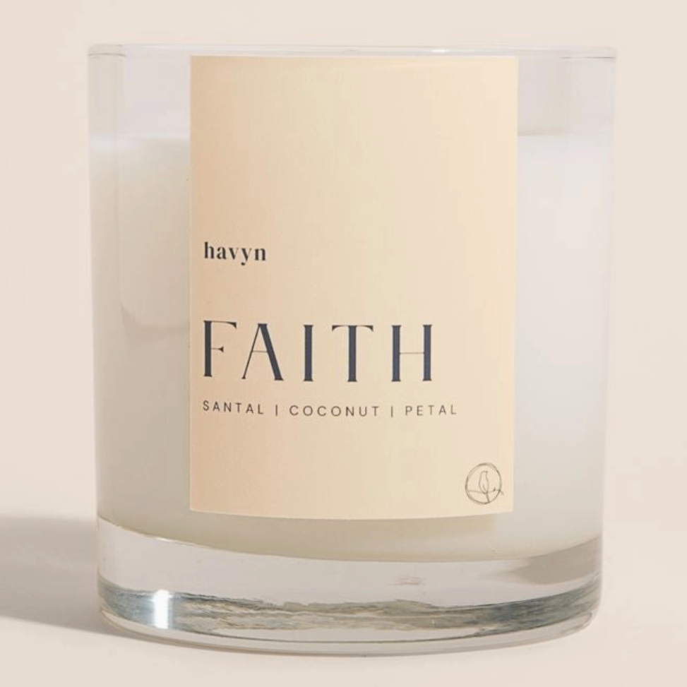 candle with beige on it by havyn that says faith santal coconut petal candle is clear with white wax 