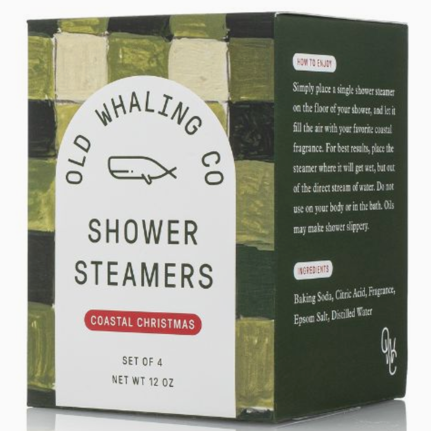 A close-up of a stack of four white shower steamers next to a box labeled "Old Whaling Co Shower Steamers" in the fragrance "Coastal Christmas." The box features a white label with a whale logo and green, black, and gold textured design elements.