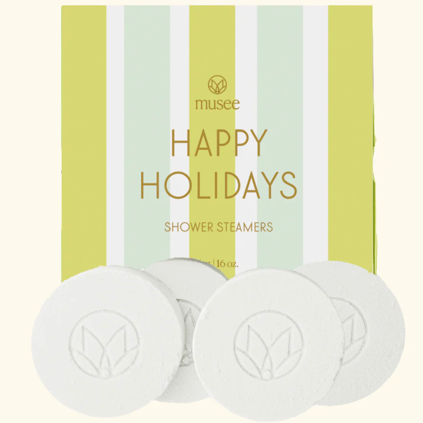 The image shows a box labeled "HAPPY HOLIDAYS" with the brand name "musee" above it. The packaging is decorated with vertical pastel stripes in green, white, and light yellow tones. Below the text, the product is identified as "SHOWER STEAMERS."

In front of the box, there are four white, round shower steamer tablets, each embossed with a minimalist floral or leaf emblem. The presentation gives a festive, refreshing vibe suitable for holiday-themed gifts or personal use.