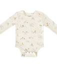 A cream-colored long-sleeve baby bodysuit with a forest-themed print featuring mushrooms and small woodland elements, displayed flat on a white background. The bodysuit has snap closures at the bottom for easy diaper changes.