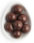 This image shows a bowl containing several glossy, round, chocolate-coated spheres. The chocolates are arranged closely together in an oval-shaped white dish, reflecting light off their shiny surfaces, suggesting a smooth and polished coating.