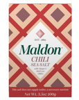 The second image displays a close-up of the Maldon Chilli Sea Salt box against a white background. The design is identical, with red, cream, and dark pink diamonds forming a bold geometric pattern. The text on the box highlights that the salt is flavored with Aleppo and bird's eye chilies, and it states, "This salt does not supply iodine, a necessary nutrient." The net weight is 3.5 oz (100g).
