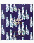 chocolate bar package with a deep blue background. The text "Polar Night" is prominently displayed in elegant, gold-colored font in the center. Above it, "Goodio Craft Chocolate" is written in a smaller font, while below it, the text "Craft Chocolate with Arctic Bramble, Lingonberry & Sea Salt" is included. There are abstract, icy white shapes resembling falling icicles or light beams across the design, giving a frosty, wintery feel. The chocolate bar's weight is indicated as 48g (1.7 oz)